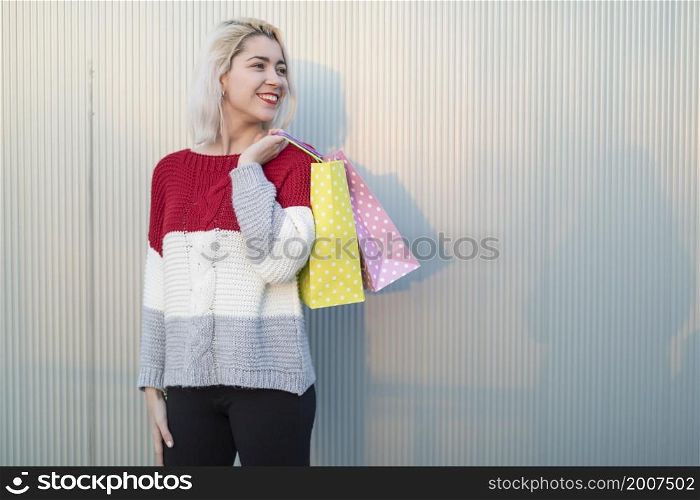 Woman in shopping. Happy woman with shopping bags enjoying in shopping. Consumerism, shopping, lifestyle concept. beautiful young blonde woman smiling with shopping bags outside