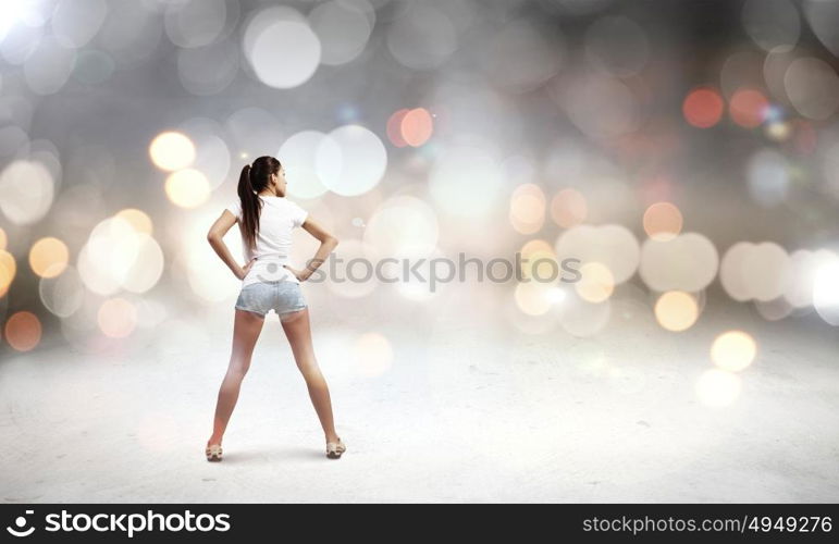 Woman in shorts. Rear view of young woman in shorts and white t-shirt