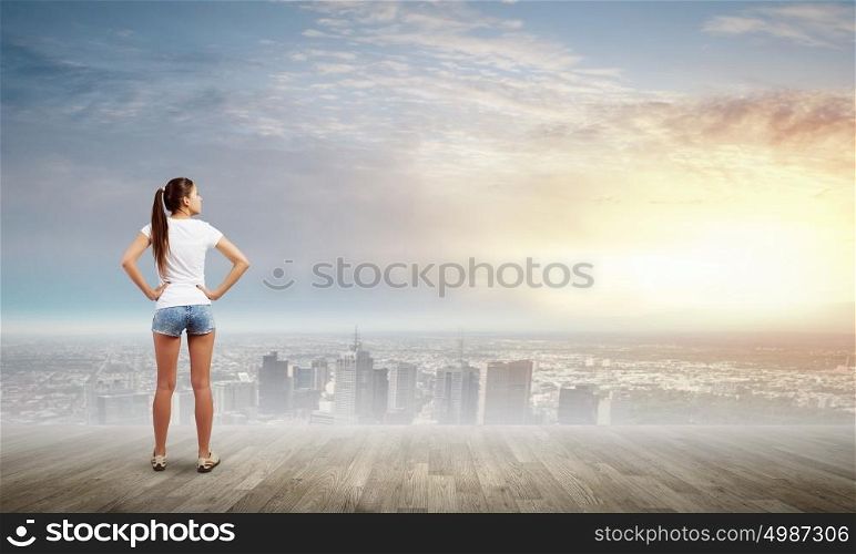 Woman in shorts. Rear view of young woman in shorts and white t-shirt