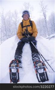 Woman in Snowshoes Sitting in Snow