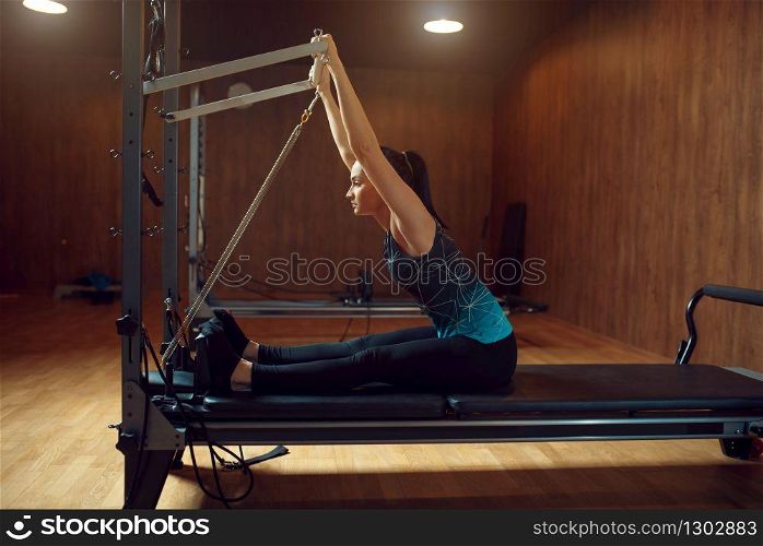 Woman in sportswear doing stretching pilates exercise in gym. Fitness workuot in sport club. Athletic female person, aerobics. Woman doing stretching pilates exercise in gym