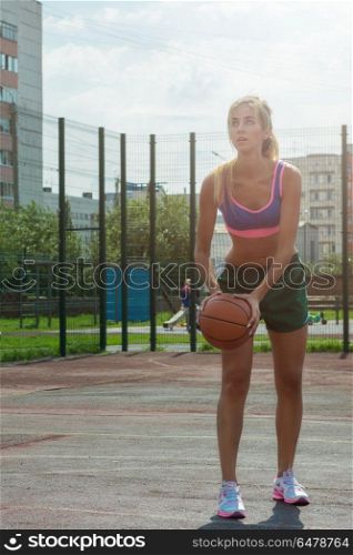 woman in sportswear with basketball ball. A young beauty athletic woman in sportswear with basketball ball