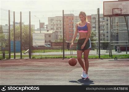woman in sportswear with basketball ball. A young beauty athletic woman in sportswear with basketball ball