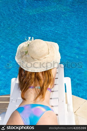 Woman in straw hat having a rest at pool