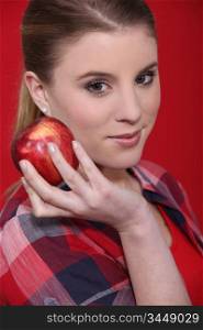 Woman in studio eating red apple