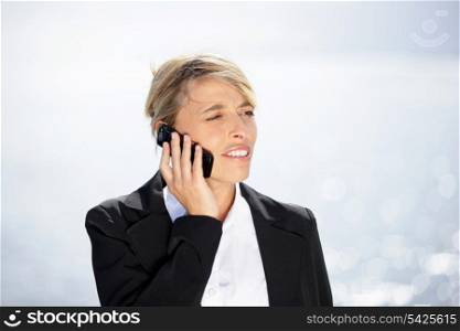 Woman in suit with mobile phone outdoors