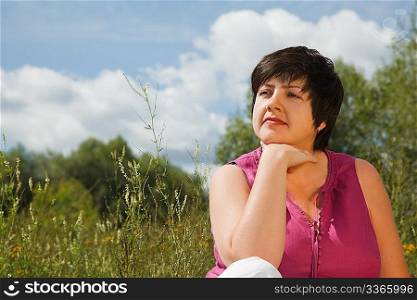 woman in summer day thinks of what that on the nature, looking forward