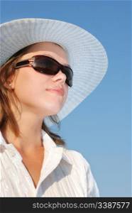 woman in sunglasses and a hat . The adult girl in white clothes