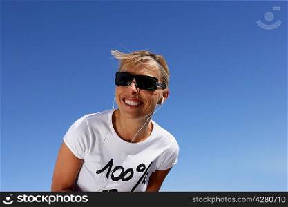 Woman in sunglasses listening to music through headphones