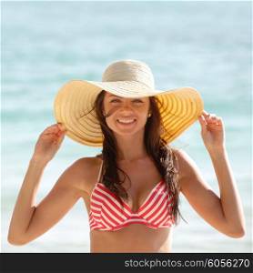 Woman in sunhat on beach. Portrait of a beautiful young woman in sunhat on beach