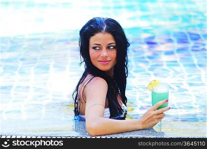 Woman in swimming pool with cocktail