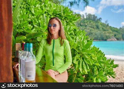 Woman in swimsuit at beach bar on Anse Intendance beach at Seychelles, Mahe