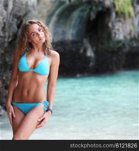 Woman in thai beach. Beautiful woman in bikini posing in thai beach with rocks on background