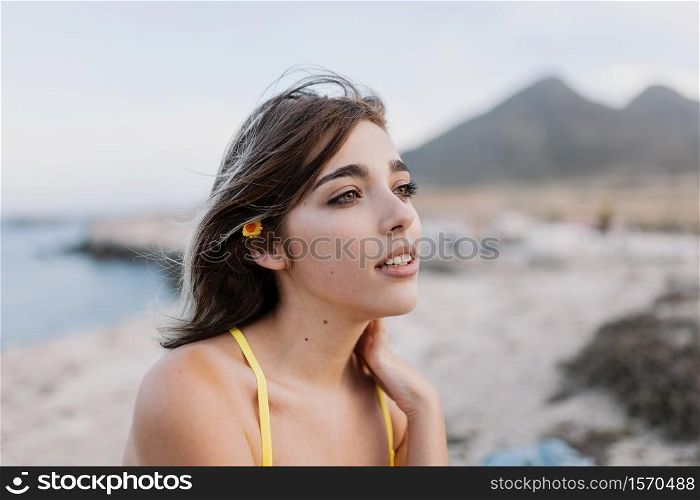Woman in the beach wearing yellow swimsuit