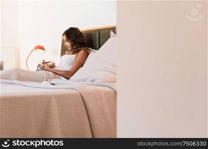 Woman in the bed writting notes on her diary