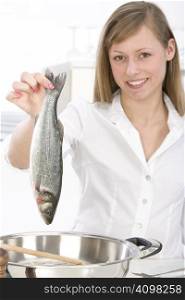 woman in the kitchen with fish in hand