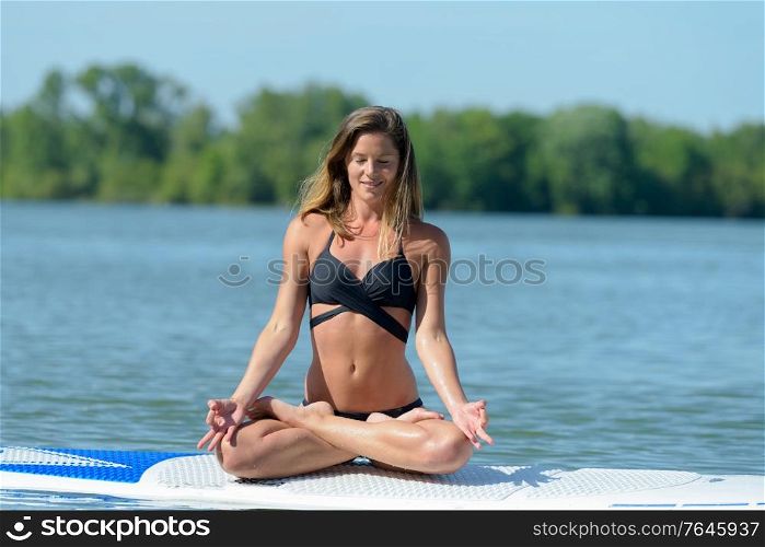 woman in the lotus position on a paddle board