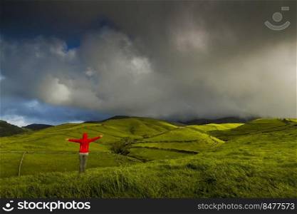 Woman in the top of a hill comtemplating the beauty of nature, Azores Island.