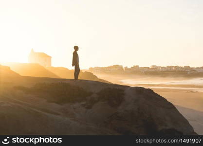 Woman in the top of a rock enjoying the beach view