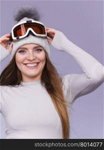 woman in thermal underwear ski googles . Attractive woman in winter cap gray sports thermal underwear for skiing training ski googles studio shot on blue.