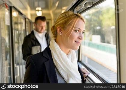 Woman in train looking pensive on window smiling travel commuting