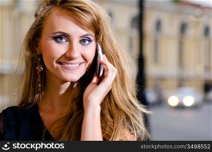 woman in trendy dress is talking phone on street