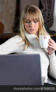 Woman in turtle-neck sweater holding mug of coffee