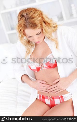 Woman in underwear looking at her waist
