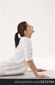 Woman in upward facing dog position over white background