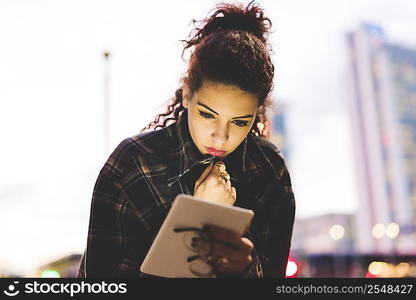 Woman in urban area using digital tablet, Milan, Italy