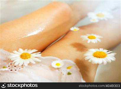 Woman in water with daisies floating on surface