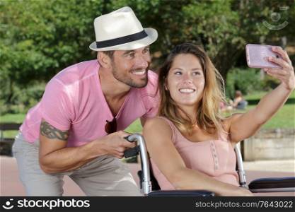 woman in wheelchair taking a selfie with boyfriend
