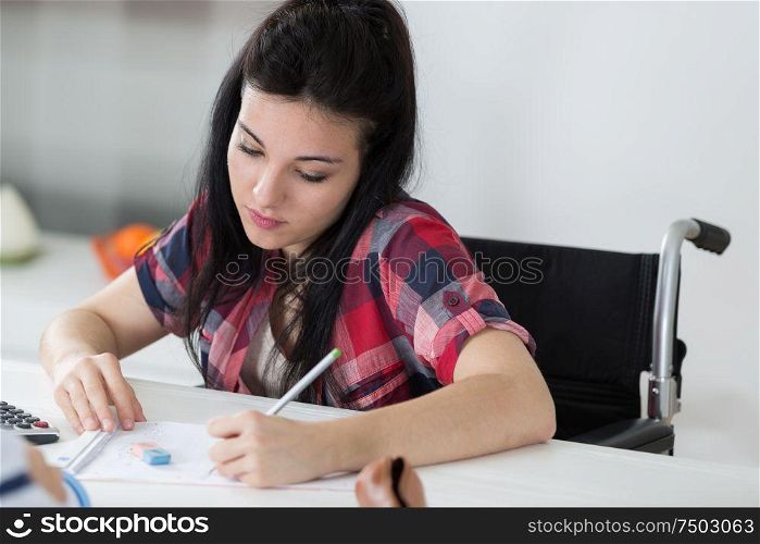 woman in wheelchair writing notes