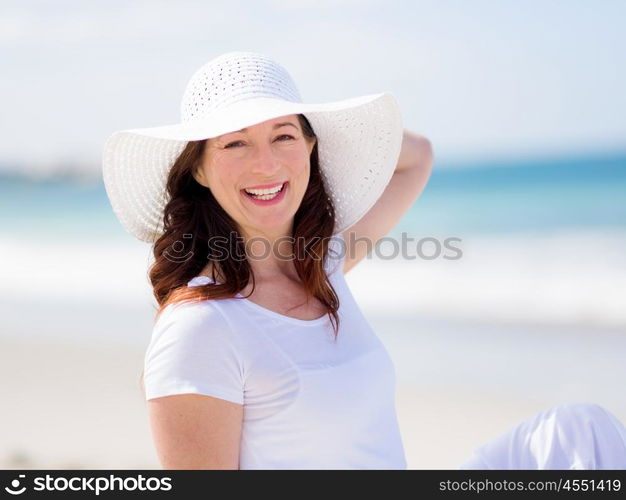 Woman in white clothes on the beach on sunny day. Beautiful day on the beach