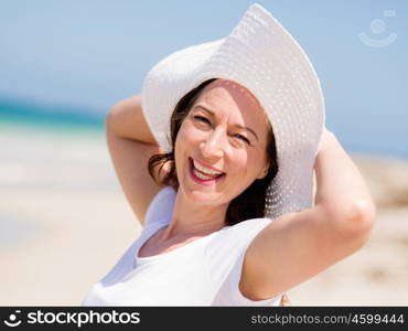 Woman in white clothes on the beach on sunny day. Beautiful day on the beach