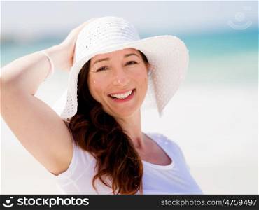 Woman in white clothes on the beach on sunny day. Beautiful day on the beach