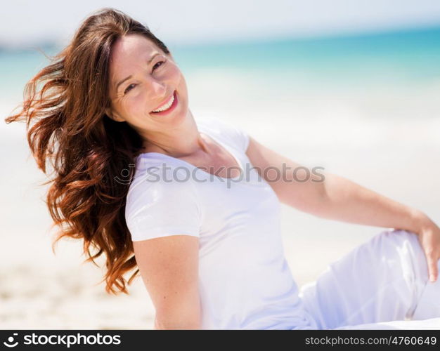 Woman in white clothes on the beach on sunny day. Beautiful day on the beach