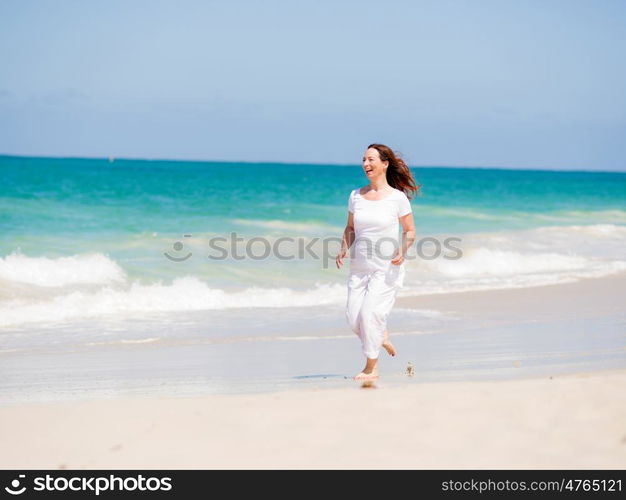 Woman in white clothes on the beach on sunny day. Beautiful day on the beach