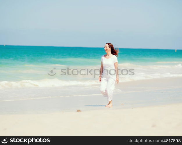 Woman in white clothes on the beach on sunny day. Beautiful day on the beach