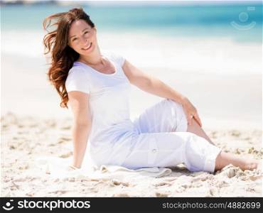 Woman in white clothes on the beach on sunny day. Beautiful day on the beach