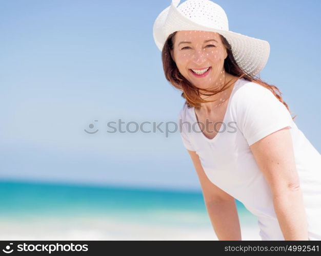 Woman in white clothes on the beach on sunny day. Beautiful day on the beach