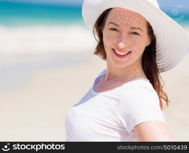 Woman in white clothes on the beach on sunny day. Beautiful day on the beach