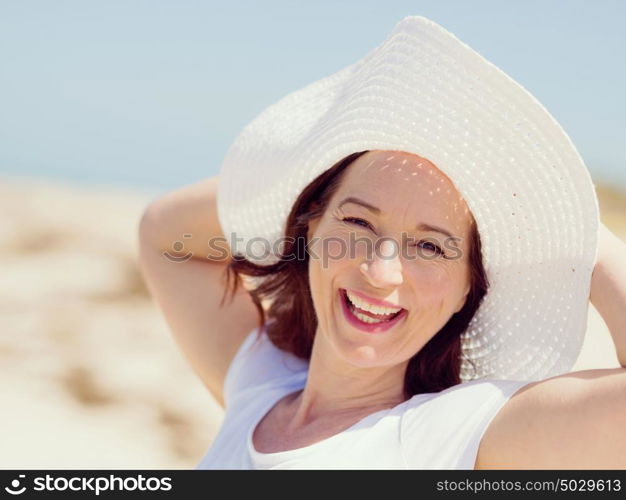 Woman in white clothes on the beach on sunny day. Beautiful day on the beach