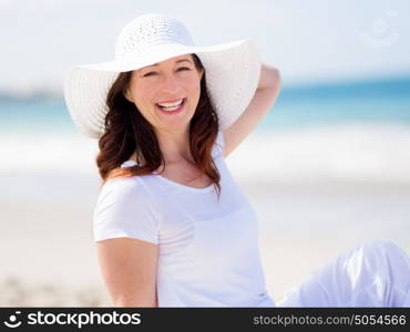 Woman in white clothes on the beach on sunny day. Beautiful day on the beach