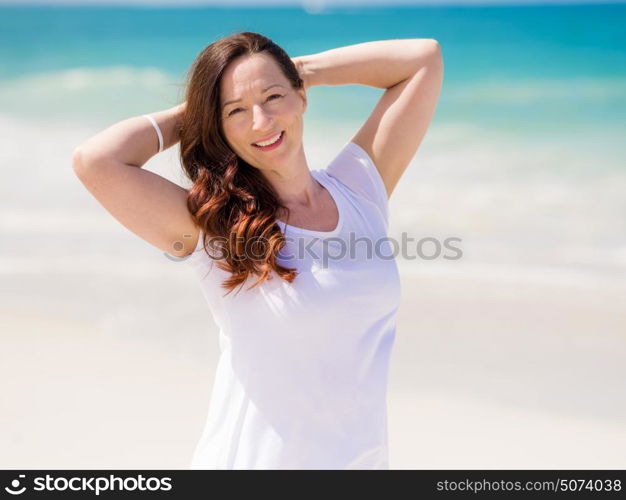 Woman in white clothes on the beach on sunny day. Beautiful day on the beach