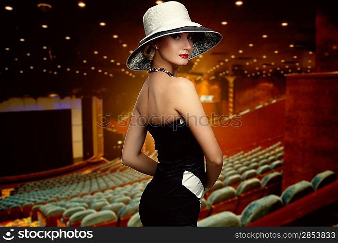 Woman in white hat in theatre interior