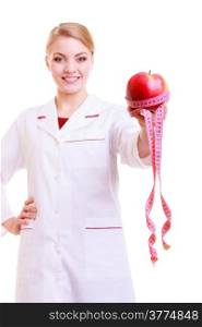 Woman in white lab coat recommending healthy food. Doctor dietitian holding fruit apple and measture tape isolated. Diet.
