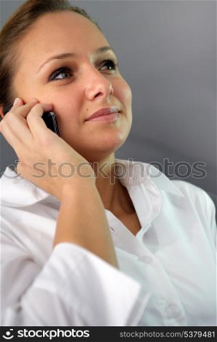 Woman in white shirt making a phone call