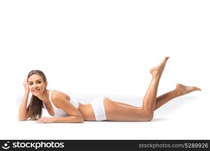 Woman in white underwear. Young beautiful woman in white cotton underwear laying on floor isolated on white background