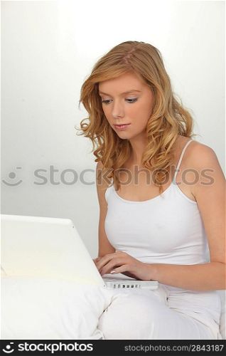 Woman in white with a white laptop